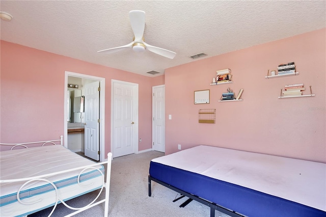 bedroom with connected bathroom, ceiling fan, carpet floors, and a textured ceiling