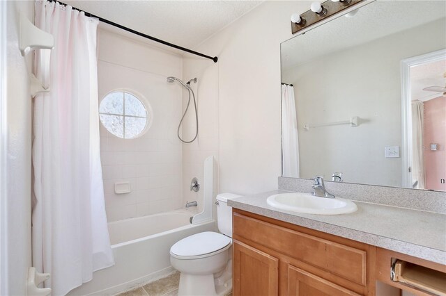 full bathroom featuring vanity, toilet, tile patterned floors, a textured ceiling, and shower / bath combo with shower curtain