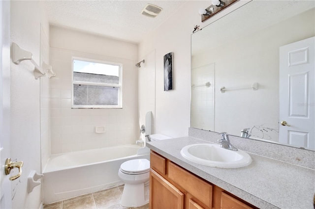 full bathroom featuring tile patterned flooring, tiled shower / bath combo, vanity, a textured ceiling, and toilet