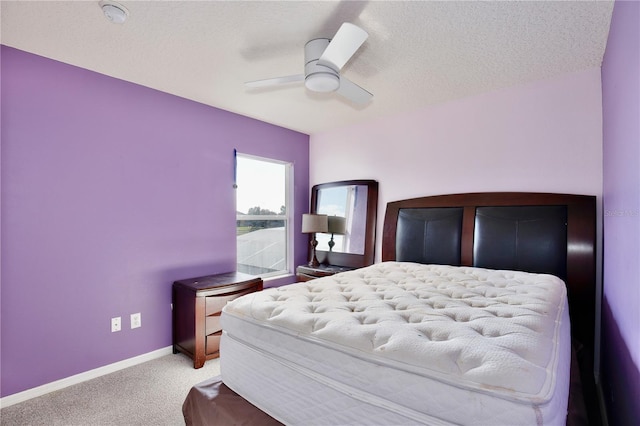 carpeted bedroom with ceiling fan and a textured ceiling