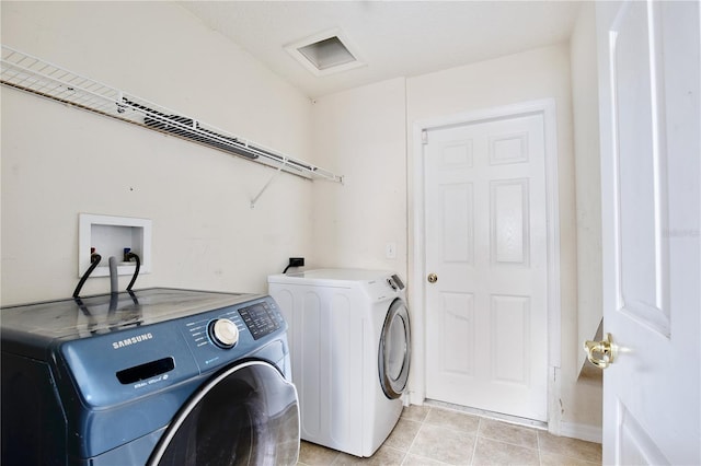 washroom featuring washing machine and dryer and light tile patterned floors