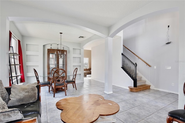 tiled dining space featuring built in features and a textured ceiling