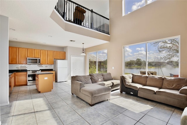 living room featuring light tile patterned floors and a water view