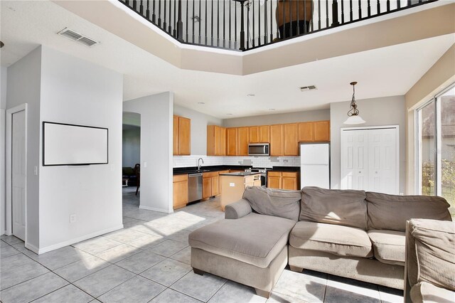 tiled living room with a towering ceiling and sink