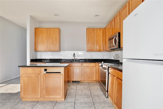 kitchen with light brown cabinetry, light tile patterned floors, sink, and appliances with stainless steel finishes