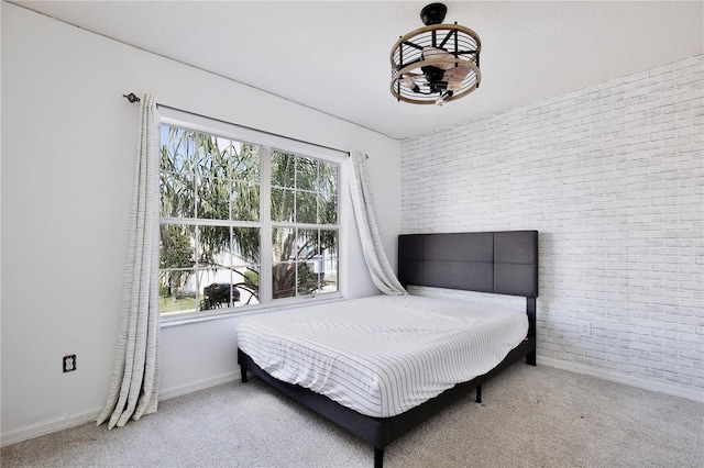 carpeted bedroom featuring brick wall and multiple windows