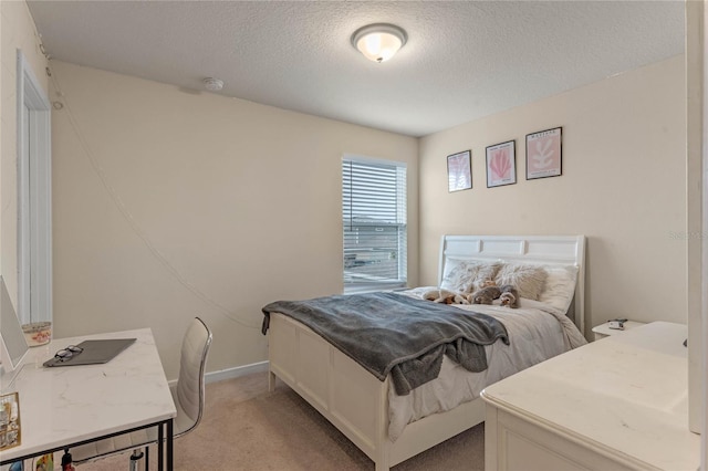 bedroom featuring light colored carpet and a textured ceiling