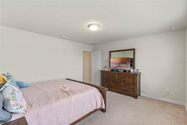 bedroom with light carpet and a textured ceiling