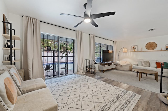 living room with light wood-type flooring and ceiling fan