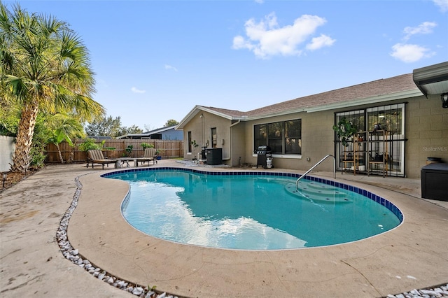 view of swimming pool with cooling unit, area for grilling, and a patio