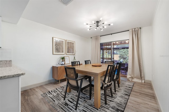 dining area with an inviting chandelier and light hardwood / wood-style floors