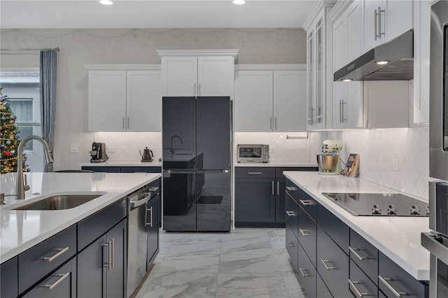 kitchen with decorative backsplash, white cabinetry, sink, and black appliances