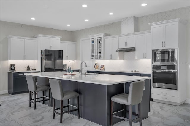 kitchen with white cabinetry, stainless steel oven, and sink