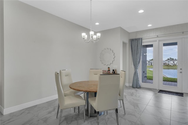 dining area featuring a water view and an inviting chandelier