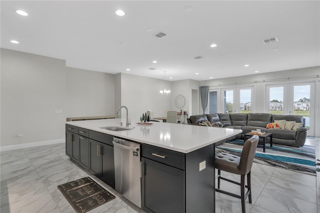 kitchen featuring a breakfast bar, sink, a center island with sink, a notable chandelier, and dishwasher