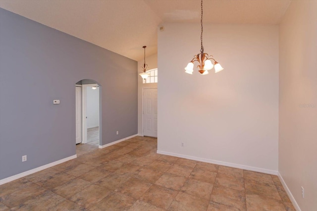 empty room with high vaulted ceiling and a chandelier