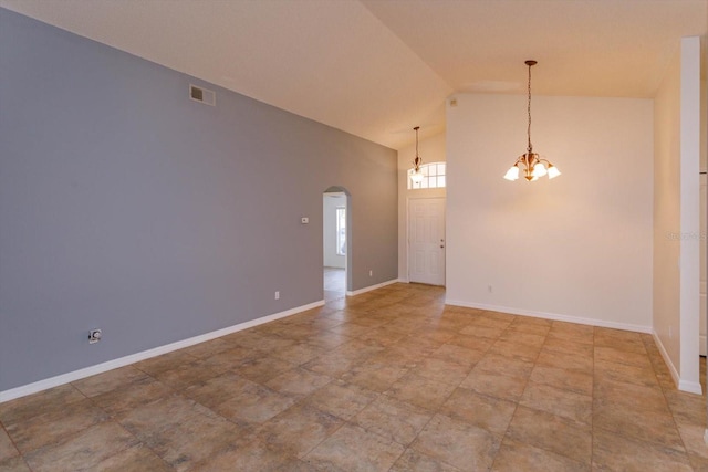 empty room featuring high vaulted ceiling and an inviting chandelier