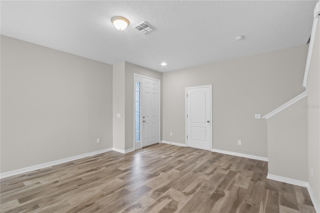 interior space featuring a textured ceiling and light hardwood / wood-style flooring