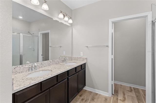 bathroom with hardwood / wood-style floors, vanity, and walk in shower