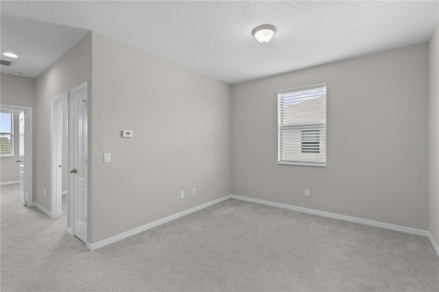 carpeted empty room with a textured ceiling