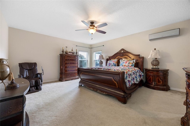 carpeted bedroom featuring ceiling fan, a textured ceiling, and a wall unit AC