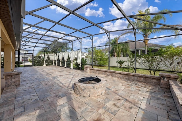 view of patio with glass enclosure and a fire pit