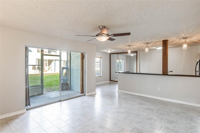 spare room featuring ceiling fan, light tile patterned flooring, and a textured ceiling