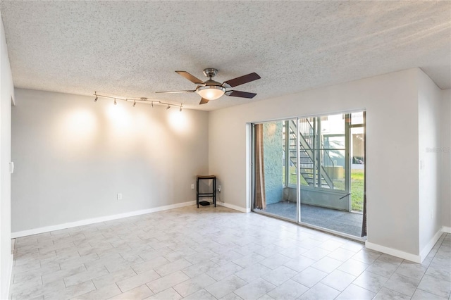 spare room featuring a textured ceiling, ceiling fan, and track lighting