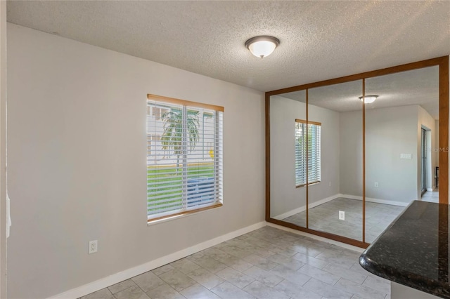 unfurnished bedroom with a textured ceiling and a closet