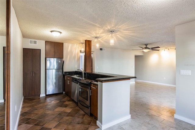 kitchen with sink, ceiling fan, a textured ceiling, kitchen peninsula, and stainless steel appliances