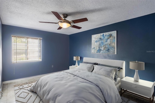 tiled bedroom featuring ceiling fan and a textured ceiling