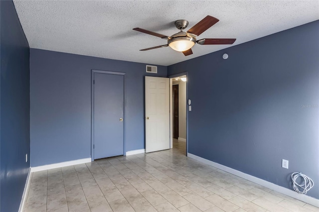 empty room featuring ceiling fan and a textured ceiling