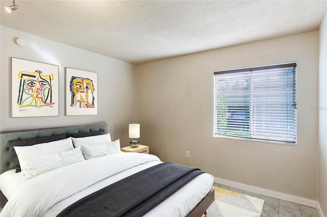 bedroom with light tile patterned floors and a textured ceiling