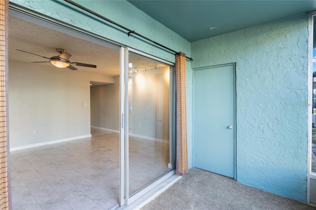 interior space with ceiling fan and a textured ceiling