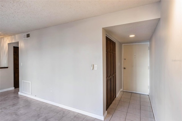 hall featuring a textured ceiling