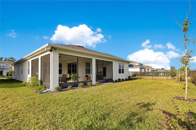 rear view of property with a lawn and a sunroom