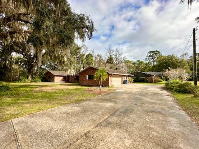 ranch-style home with a garage, an outdoor structure, and a front lawn