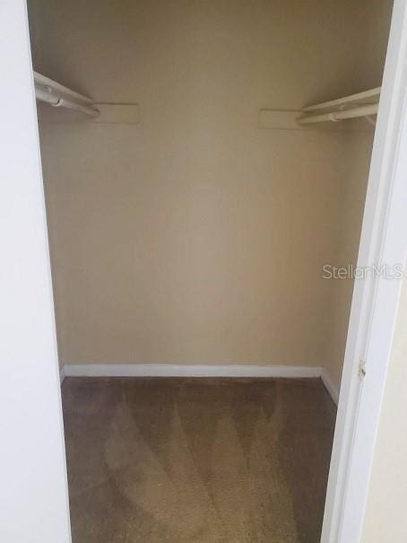 spacious closet featuring dark colored carpet