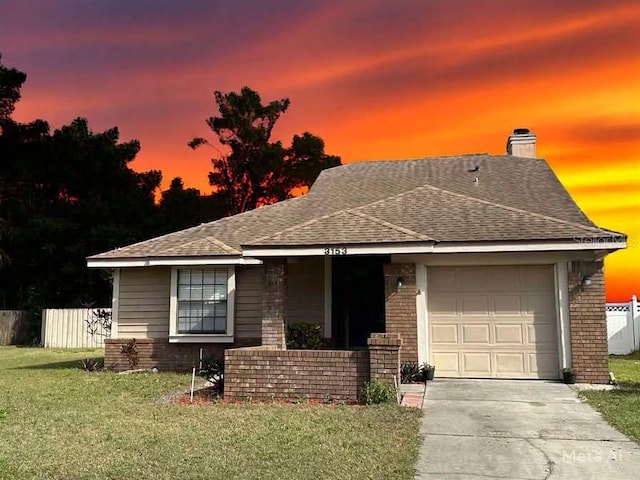 view of front of property featuring a garage and a lawn