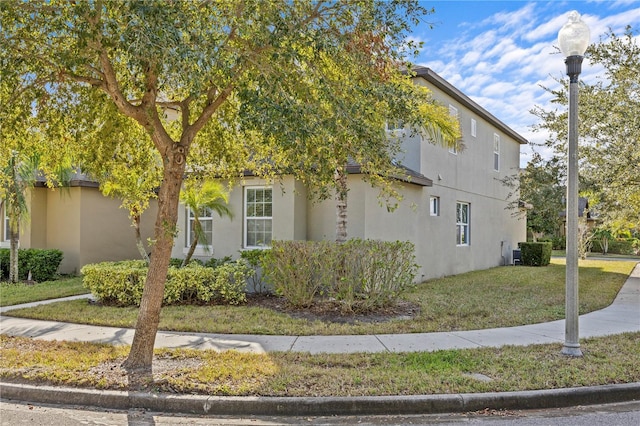 view of property exterior with a yard and central air condition unit