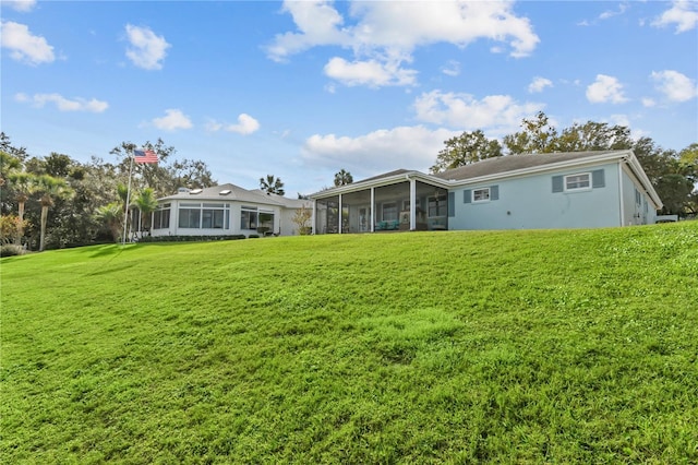 rear view of property with a yard and a sunroom