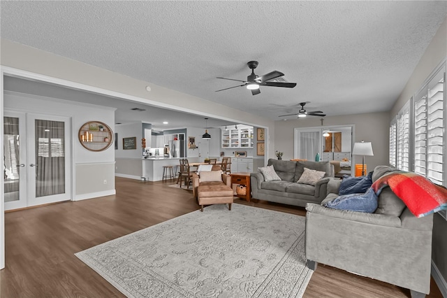 living room featuring hardwood / wood-style floors, ceiling fan, and a textured ceiling