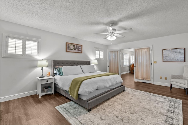 bedroom with a textured ceiling, dark hardwood / wood-style flooring, and ceiling fan