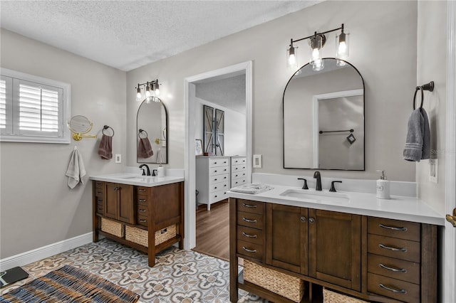 bathroom featuring tile patterned floors, vanity, and a textured ceiling