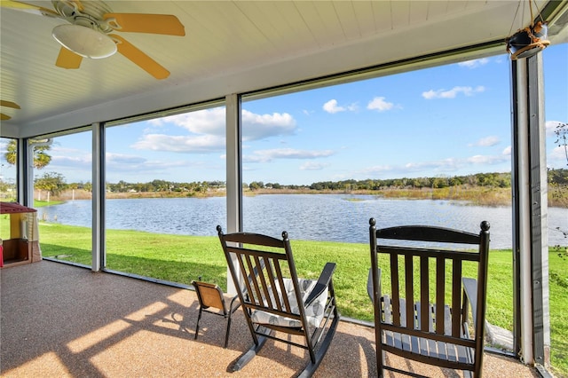 sunroom featuring ceiling fan and a water view