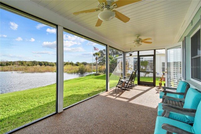 unfurnished sunroom with a water view and ceiling fan