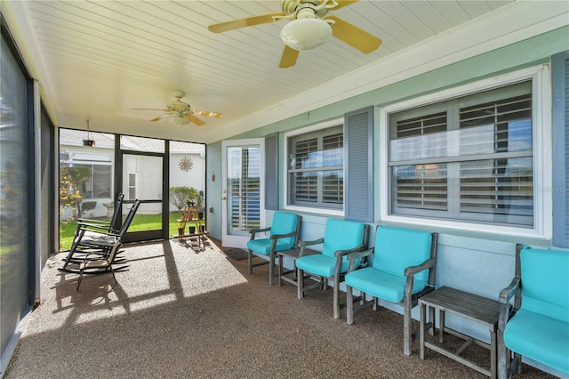 unfurnished sunroom featuring ceiling fan