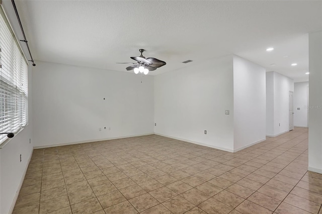 tiled spare room with ceiling fan