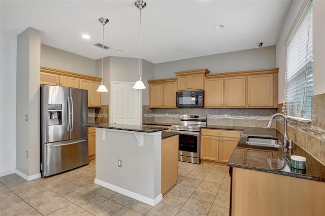 kitchen featuring backsplash, dark stone counters, stainless steel appliances, sink, and a kitchen island