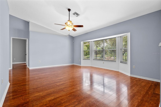 empty room with dark hardwood / wood-style floors, ceiling fan, and vaulted ceiling